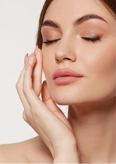 Close-up of a woman with eyes closed, touching her face