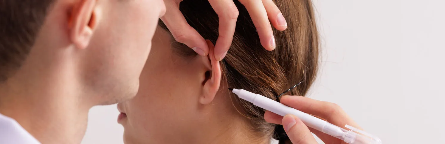 A doctor prepping his patient for an ear reconstruction surgery
