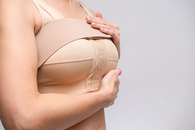 Woman wearing a compression bra after breast lift surgery