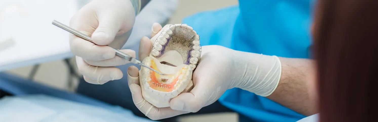 An orthodontist showing a patient her teeth alignment