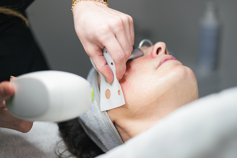 A cosmetic surgery specialist performing laser skin treatment