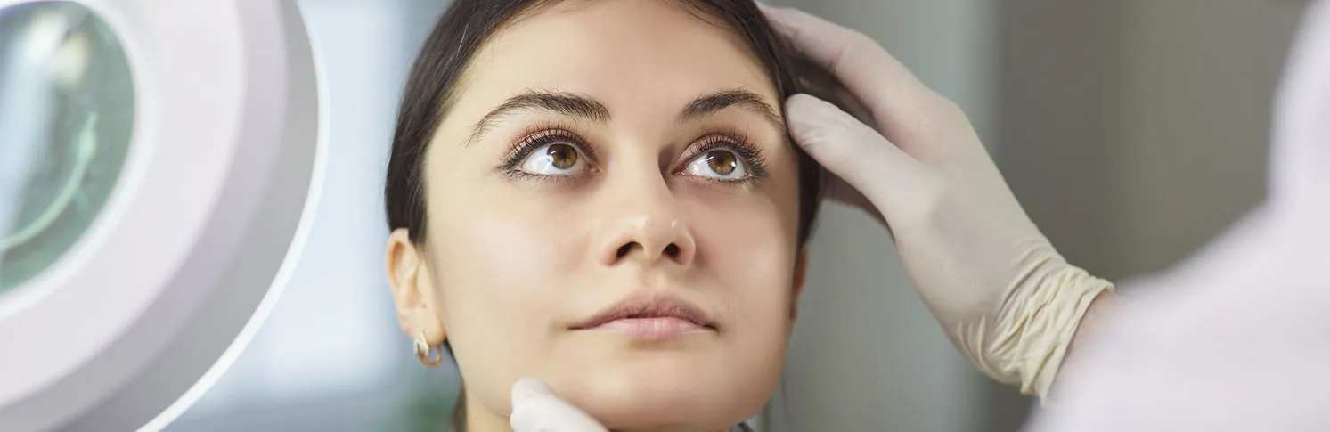 A specialist assessing a patient’s first rhinoplasty results