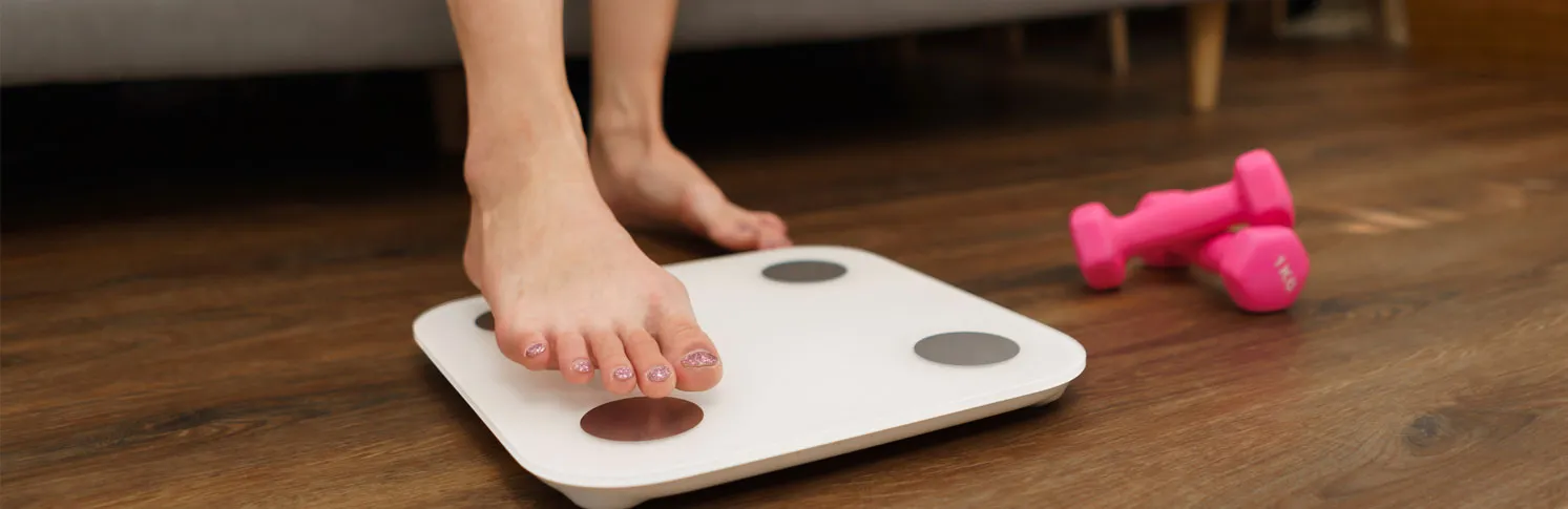 A woman weighing herself before her breast lift