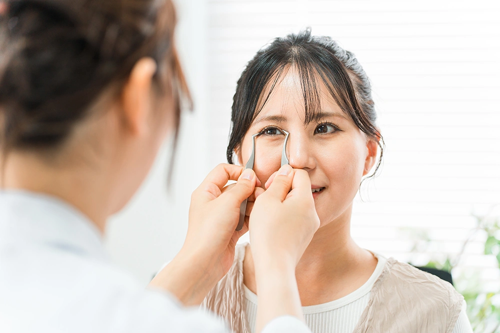 A surgeon measuring a patient’s eyelids during surgery planning